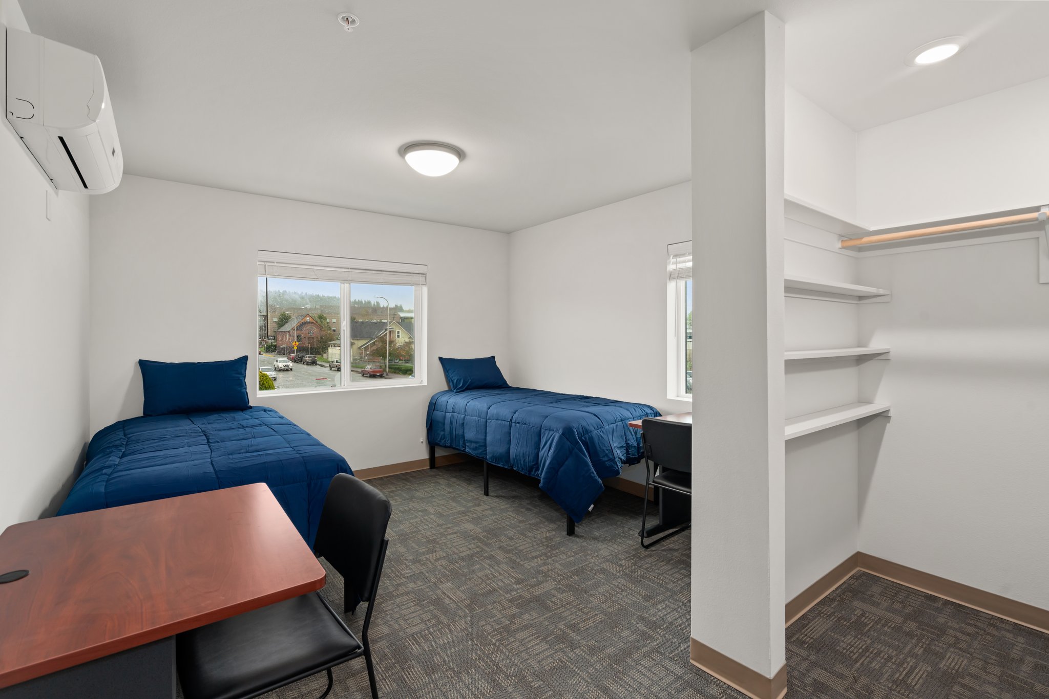 View of a typical bedroom showing two beds and two desks.