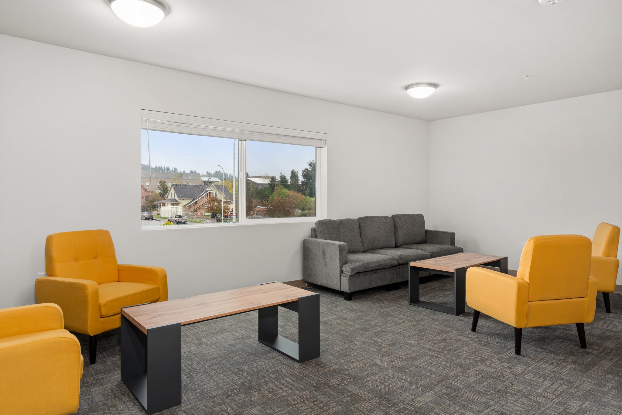 View of sitting area with coffee tables and comfortable couch and chairs.